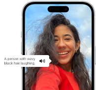 iPhone 15 displaying a Voiceover announcement describing a photograph as: a person with wavy black hair laughing
