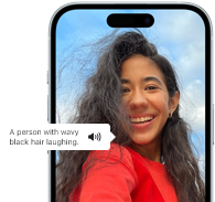 Voiceover på iPhone 15 beskriver en bild med orden en skrattande person med vågigt svart hår